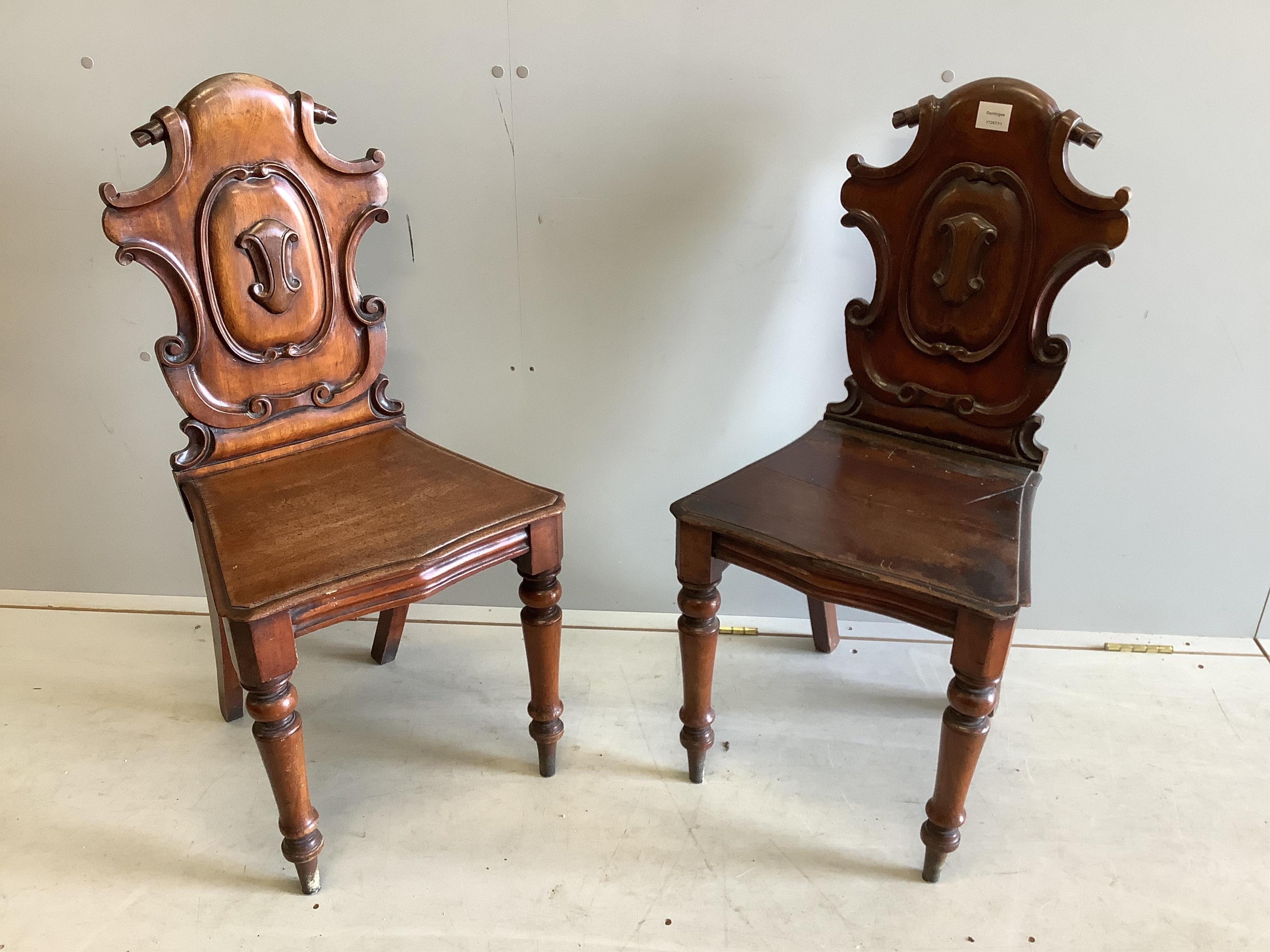 A pair of Victorian carved mahogany hall chairs, width 44cm, depth 39cm, height 90cm. Condition - poor to fair